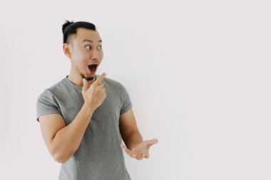 Gri tişörtlü Asyalı adamın mutlu yüzü beyazla izole edilmiş..