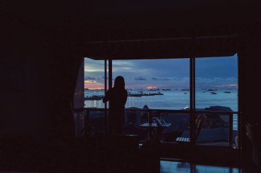 Alacakaranlık deniz manzarası gökyüzü ve bir apartmanın penceresinden Asya köyü.