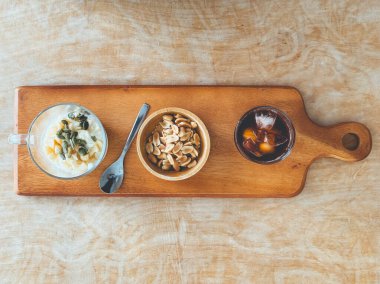 Sağlıklı atıştırmalık fasulye tohumu yoğurt ve ahşap tabakta buzlu kahve..