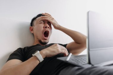 Yaratıcı tasarımcı Asyalı adam çalışırken kanepede kestiriyor..