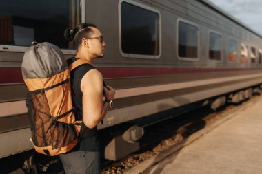 Tren istasyonunda bekleyen Asyalı turist gezgini..
