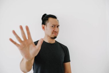 Siyah tişörtlü Asyalı adam, beyaz üzerinde yalnız poz vermeyi reddediyor..