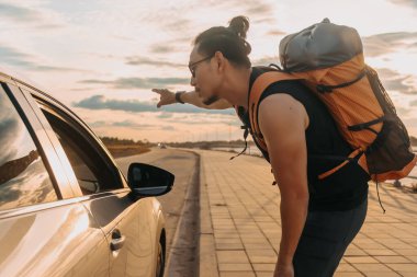 Asyalı turist sırt çantalı gezgin gideceği yere gitmek istiyor..