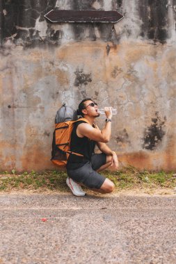Turist gezgini Asyalı adam güneş çok sıcak olduğu için dinleniyor..