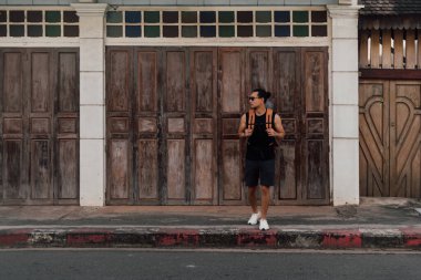 Asya 'nın eski kasabasında Asya turisti sırt çantalı bir adam karşıdan karşıya geçiyor.