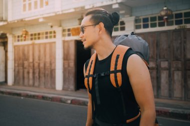 Asya 'nın eski kasabasında Asya turisti sırt çantalı bir adam karşıdan karşıya geçiyor.