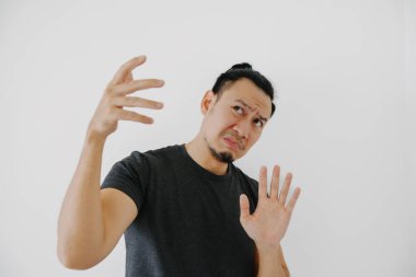 Siyah tişörtlü Asyalı adam, beyaz üzerinde yalnız poz vermeyi reddediyor..