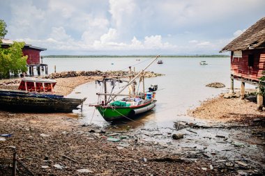 Düşük gelgit sırasında tekneleri evlerin yakınına yanaşmış taşralı deniz kenarı topluluğu.