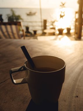 Sıcak içecek, sıcak öğleden sonra atmosferinde kırsal yüzeye gölge düşürüyor.