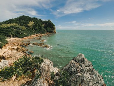 Açık gökyüzü ve kayalık burunlarıyla güzel deniz manzarası