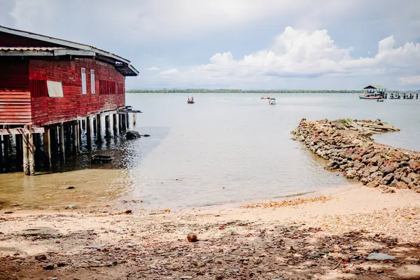Kıyı balıkçı kulübesi alçak gelgit sırasında kıyı şeridi yakınında ayakta duruyor.