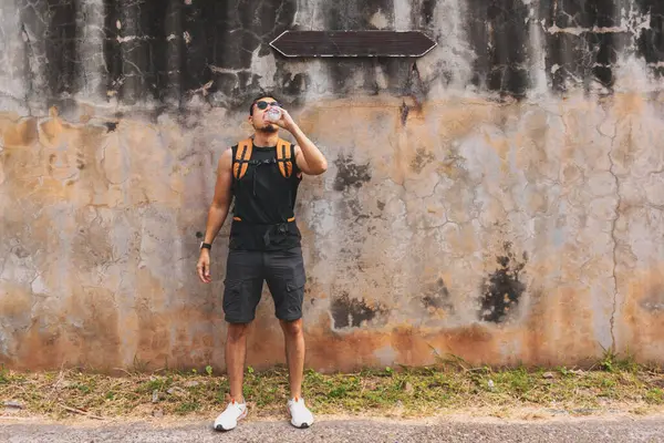 Asya 'nın sıcak sokaklarında su içen Asyalı turist..