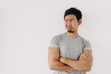 Genç Asyalı erkek yana bakarken şüpheli ya da şüpheli görünüyor.