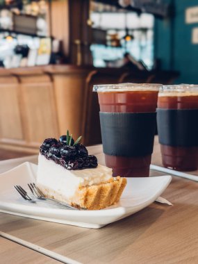 Taze yaban mersinli lezzetli tatlı ve kafe ortamında kahve.