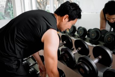Formda erkek, antrenman öncesi ağırlık seçiyor.