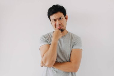 Gri gömlekli genç Asyalı erkek biraz şüpheyle yaklaşır.