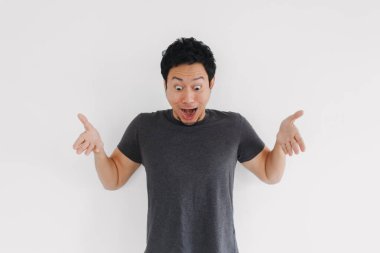 Gri gömlekli Asyalı erkek vücut dilinde belirsizlik ve kafa karışıklığı gösteriyor