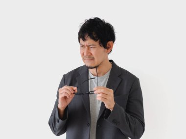 Yüzü asık gözlüklü takım elbiseli bir adam. Hayal kırıklığı ya da sıkıntı kavramı