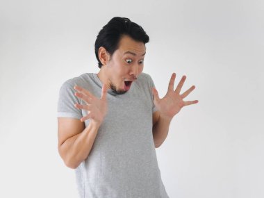 Yüzünde şaşırmış bir ifade olan bir adam gri bir gömlek giyiyor. Şok olmuş ya da şaşırmış gibi ellerini havada tutuyor. Şaşırtma ya da güvensizlik kavramı