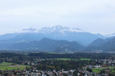 Sis kaplı Alpler Salzburg Vadisi 'ne tepeden bakan karlı tepeler ve manzaralı yeşillikler. Avusturya kırsalında sakin bir Alp manzarası. Yüksek kalite fotoğraf