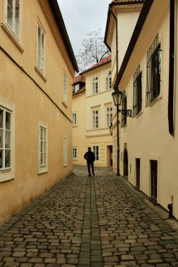 Prag 'daki Sarı Binalarla çevrili Çakıl Taşı Sokağı' nda Yürüyen Bir Adamın Siyah Silueti. Yüksek kalite fotoğraf