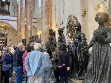 Innsbruck, Avusturya - 29 Eylül 2024: Hofkirche 'de Kılavuz Bronz Heykeller ile Kıdemli Tur Grubu. Yüksek kalite fotoğraf