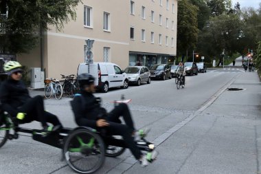 Salzburg, Avusturya - Ekim 12024: Arka planda bulunan Bulanık Hareket, Yayalar ve Park 'ta, Avrupa Mahallesi' nde, Residential Street 'ten Uzatılmış Bisikletçiler Geçiyor. Yüksek kalite