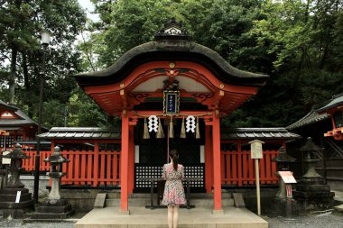 Kyoto, Japonya - 25 Temmuz 2017: Fushimi Inari Taisha 'nın içindeki küçük bir tapınakta dua eden kadın. Yüksek kalite fotoğraf