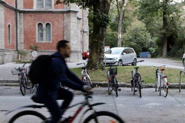 Salzburg, Avusturya - Ekim 12024: Bulanık Bisikletli Pas Geçidi Bir Avrupa Mahallesi 'nde Sessiz Bisiklet Sürme, Arkaplanda Tarihi Binalar ve Ağaçlar, Şehir Yaşam Tarzı. Yüksek kalite