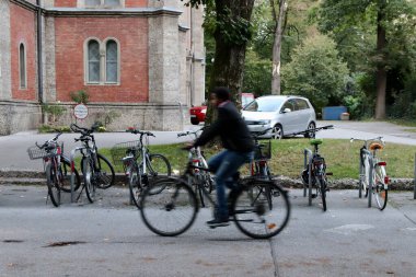 Salzburg, Avusturya - Ekim 12024: Bulanık Bisikletli Pas Geçidi Bir Avrupa Mahallesi 'nde Sessiz Bisiklet Sürme, Arkaplanda Tarihi Binalar ve Ağaçlar, Şehir Yaşam Tarzı. Yüksek kalite