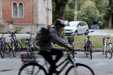 Salzburg, Avusturya - Ekim 12024: Bulanık Bisikletli Pas Geçidi Bir Avrupa Mahallesi 'nde Sessiz Bisiklet Sürme, Arkaplanda Tarihi Binalar ve Ağaçlar, Şehir Yaşam Tarzı. Yüksek kalite