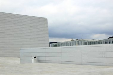 Beyaz Geometrik Duvarlar ve Bulutlu Gökyüzü Altındaki Şehir Skyline 'ı sunan Modern Minimalist Mimari. Yüksek kalite fotoğraf