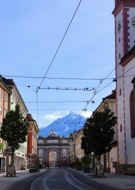 Innsbruck, Avusturya - 29 Eylül 2024: Renkli Mimari ve Görkemli Alpler tarafından çerçevelenen Maria-Theresien-Strasse Zafer Yayı 'nın çarpıcı görüntüsü. Yüksek kalite fotoğraf