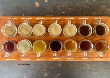 Tahta tadım tepsisindeki cam bardaklarda çeşitli çay ve kahveler. Yüksek kalite fotoğraf