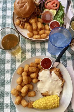  Çekilmiş domuz sandviçi, kızarmış tavuk, patates kızartması ve mısır koçanlı Amerikan yemeği. Yüksek kalite fotoğraf