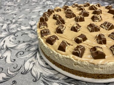 Dekoratif masa örtüsü üzerine çikolatalı peynirli fırınlanmamış karamel peynirli kek, yakın çekim perspektifi. Yüksek kalite fotoğraf