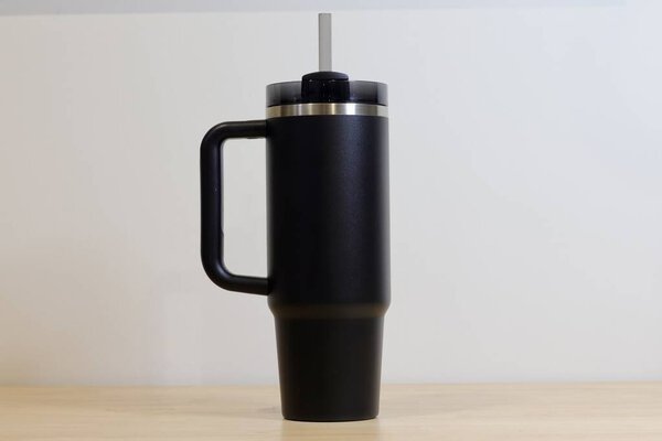 Isolated Black Insulated Tumbler with Straw Against White Background. Reusable, Eco-friendly, and Portable Beverage Container for Everyday Hydration. High quality photo