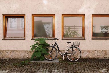 Tahta pencereli, taşralı bir duvara park edilmiş klasik bisiklet. Yüksek kalite fotoğraf