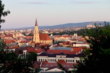 Aziz Michaels Kilisesi ve tarihi çatılarıyla Cluj-Napoca Skyline 'ın Altın Saat Manzarası. Yüksek kalite fotoğraf