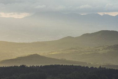 artistic view on the volcano mountains in summer of nature area of the Auvergne at sunset