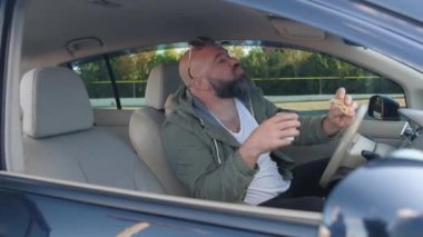 Rahat bir erkek taksi şoförü arabada yer, yemeğin tadını çıkarır. Adam müşteriyi fark eder ve onu el hareketleriyle arabada oturmaya çağırır..