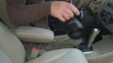 Kapüşonlu ve güneş gözlüklü bir adam. Adam yolcu koltuğundan kamerayı alır ve arabanın camından fotoğraf çeker. Gözetleme kavramı, dedektif, paparazzi..