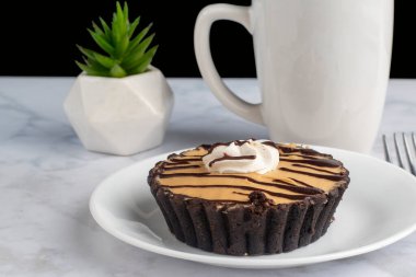 Fıstık ezmeli mus bir fincan kahveyle servis edilir.