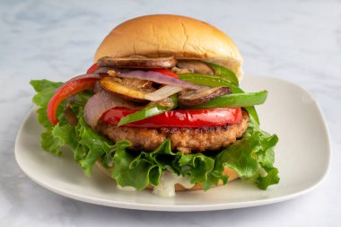 Sotelenmiş biberli somon burger soslu soğan ve mantar.