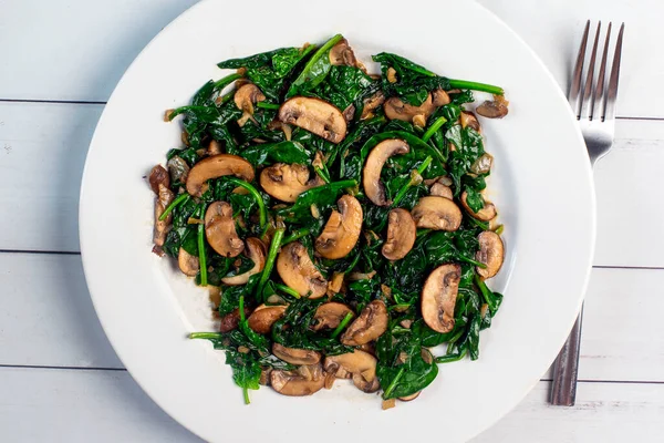 Sotelenmiş mantarla servis edilen ıspanak sote.