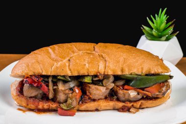 Soslu sandviçe soğan ve perrs süsleme yapar.