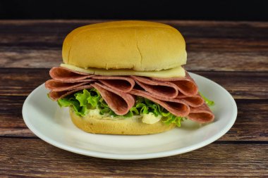 Marul mayonezli pastırma ve ekmeğin üzerinde salamura peynir.