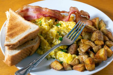 Çırpılmış yumurta, domuz pastırması ve patates kızartması.