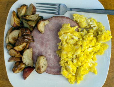 Kahvaltı tabağı omlet, jambon ve patates kızartması.