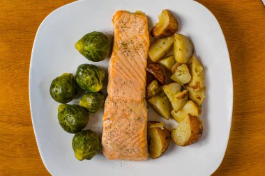 Fırında somon, brussel lahanası ve kırmızı patatesle servis edilir.